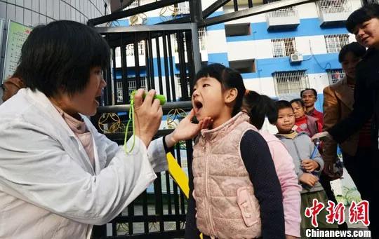 资料图:一幼儿园校医正在为入园的小朋友进行晨检。中新社发 石农兵 摄