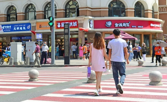 2021年七夕,一对情侣牵手走过路口 侯昭康 摄