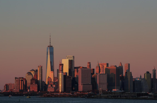  资料图片：2018年12月，美国纽约，夕阳洒在世贸中心一号楼和曼哈顿的其他建筑上。REUTERS/Brendan McDermid