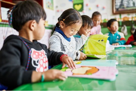 黑科村幼儿园的孩子们看着自己喜爱的绘本