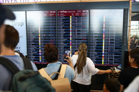 旅客在柏林勃兰登堡机场查看离港航班信息。