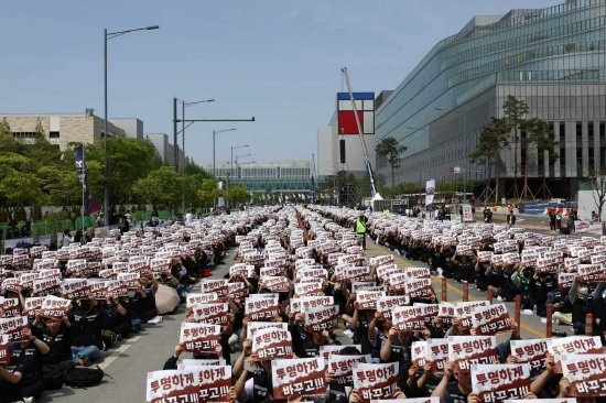 4月23日，在韩国平泽市三星电子半导体工厂外，三星电子员工在罢工前集会中举着标语牌。