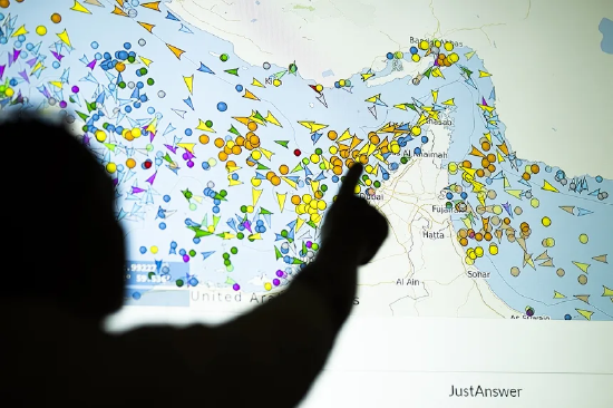 2026 年 5 月 4 日暗示图，一东说念主站在大屏前稽查船舶跟踪网站上霍尔木兹海峡船只动态。