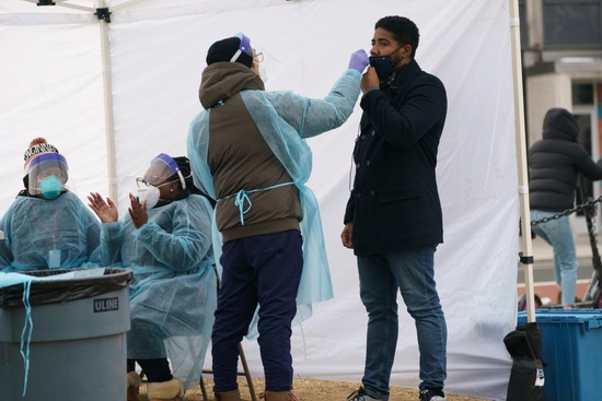 1月13日，醫護人員在美國首都華盛頓一處新冠病毒檢測點為檢測者採樣。 （新華社發，沈霆攝）