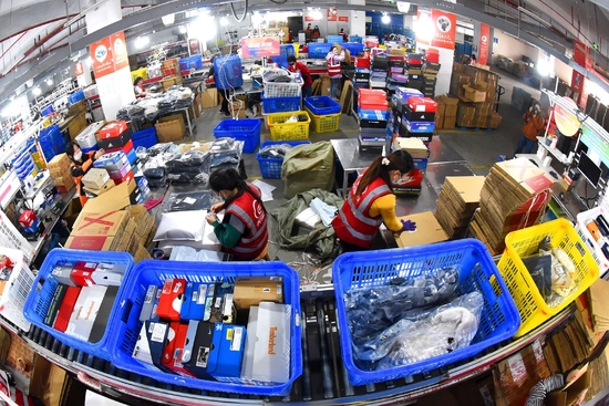 2022年11月11日，江苏连云港，海州区天马电商产业园内，工人正在查找、封装打包、发送快递包裹。 视觉中国 图