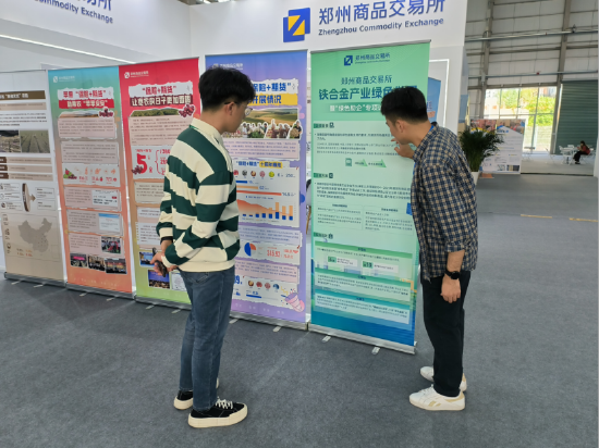 (图注:郑商所展台工作人员介绍铁合金产业绿色发展项目)