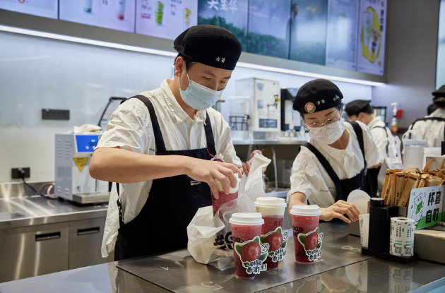 古茗门店在为消费者制作果茶饮品，其中许多由短保质期新鲜水果制成