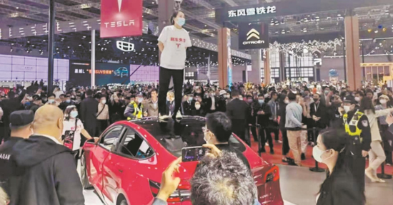 上海车展上，女子站上特斯拉车顶维权