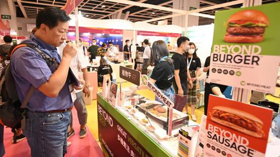 2020年11月11日，一名游客在香港会议展览中心举办的亚洲餐厅酒吧美食博览会上尝试一种植物性肉类替代品。