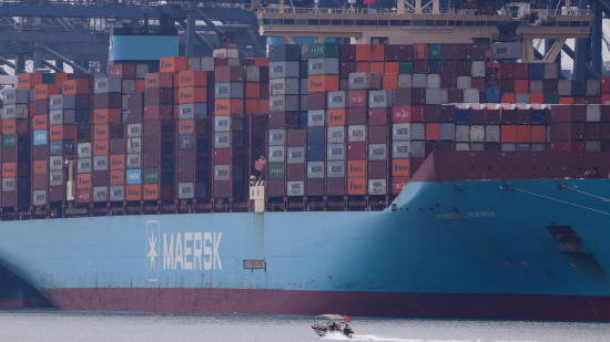 2025 年 10 月 30 日，中国广东省深圳市盐田港码头，一艘小船驶过一艘满载集装箱的货轮。