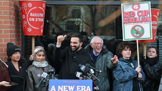 2025 年 12 月 1 日，纽约市长当选人佐兰・曼达尼（左）与美国参议员伯尼・桑德斯，现身纽约声援罢工的星巴克员工。