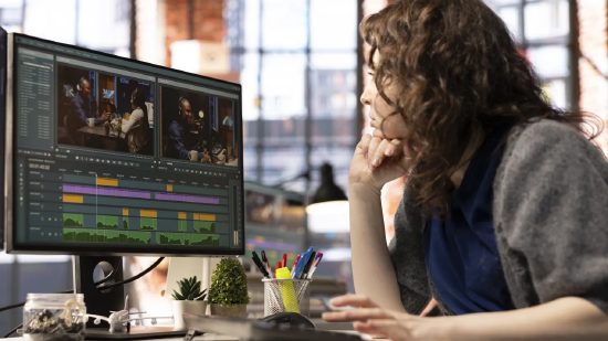 在广告公司办公室，一位专注的女编辑正使用创意软件制作视频混剪，深耕数字媒体领域。这位影视从业者借助双显示器剪辑素材、创作内容，开展后期制作工作。