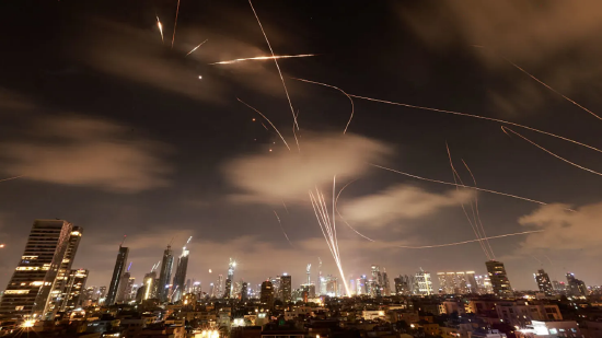 2025 年 6 月 18 日凌晨，以色列特拉维夫上空，以色列防空系统启动拦截伊朗导弹。6 月 17 日，以伊再次交火，这是双方历史上最激烈对抗的第五天，引发外界对中东地区陷入长期冲突的担忧。