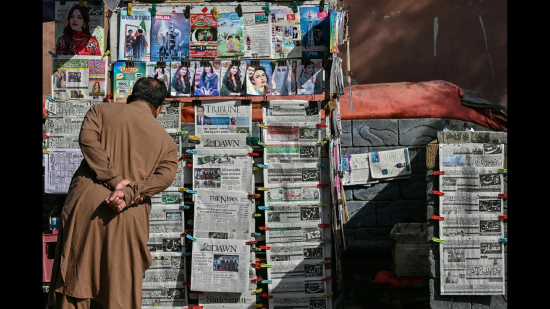 2026 年 4 月 25 日，伊斯兰堡，一名男子在路边报摊看报。当日，美国特使前往巴基斯坦首都，试图在脆弱停火背景下重启与伊朗的和平谈判，但直接对话前景仍不明朗。