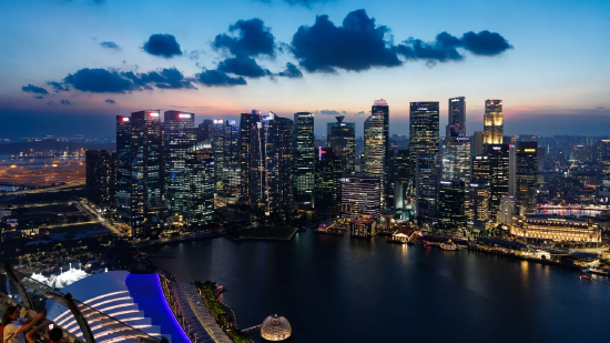 2026 年 2 月 2 日周一，黄昏时分灯火通明的新加坡商用楼宇。2025 年前三季度新加坡旅游收入同比上涨 6.5%，达到创纪录的 239 亿新元（折合 188 亿美元），全年收入有望突破 290 亿至 305 亿新元的预期区间。