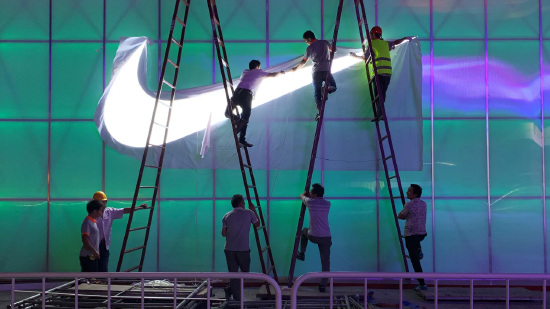 2019 年 8 月 28 日，北京五棵松体育馆外，工作人员正在安装耐克标识灯牌。