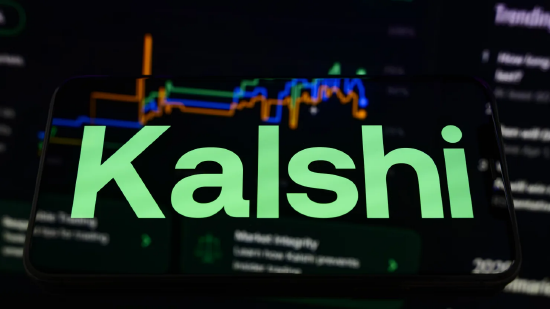 2026 年 3 月 9 日，法国克雷泰伊，一部智能手机屏幕显示 Kalshi 的品牌标识，背景投射模糊的交易行情曲线。彼时平台正卷入一桩重大丑闻以及一桩与伊朗罢工相关、涉案金额 5400 万美元的诉讼。