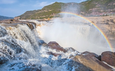 10月18日，黄河壶口景区出现彩虹飞瀑景致。当日，蓝天白云下的黄河壶口瀑布“群龙”戏瀑，彩虹卧波。 　　人民视觉