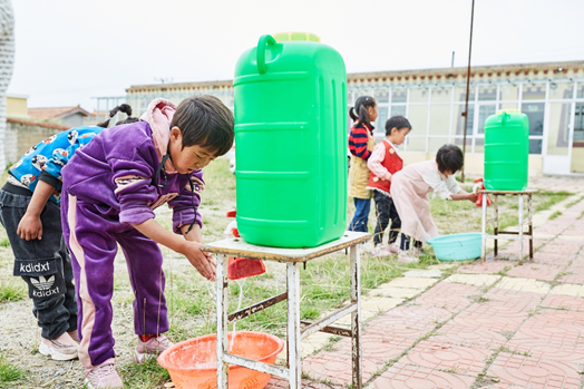 孩子们用蓄水罐里的水洗手