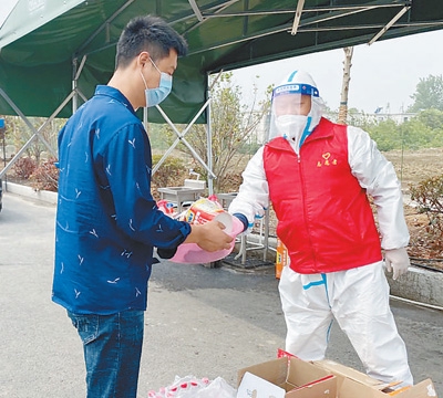 货车司机梁德过（左）在龙塘货车驿站领取方便面和矿泉水。 　　本报记者 吴 焰摄