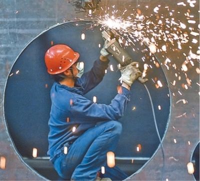 河南省洛阳市,工人在中信重工车间清理打磨出口的矿用磨机筒体。近年来,该公司在矿业及水泥重型装备制造领域深耕,市场影响力不断提升,在“一带一路”沿线订单稳步增加。 黄政伟摄(影像中国)