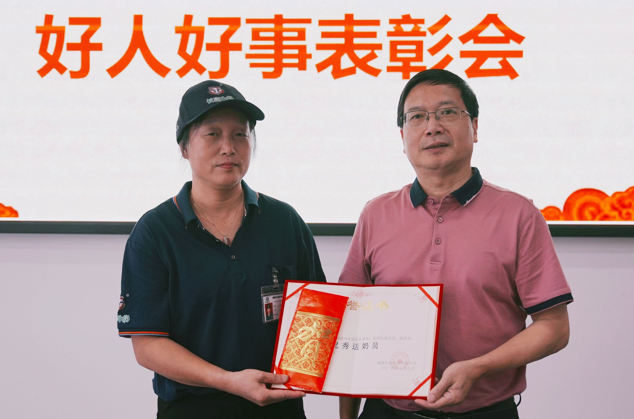 福建省奶业协会副秘书长、福建长富乳品有限公司总经理助理何水双为陈娥英颁发“优秀送奶员”荣誉证书