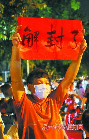 金尚小区居民手举写着"解封了"的红纸,庆祝这一难忘时刻.