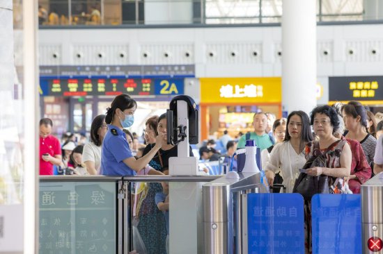 2.赣州西站工作人员正在帮助旅客验证进站乘车。邹阳 摄