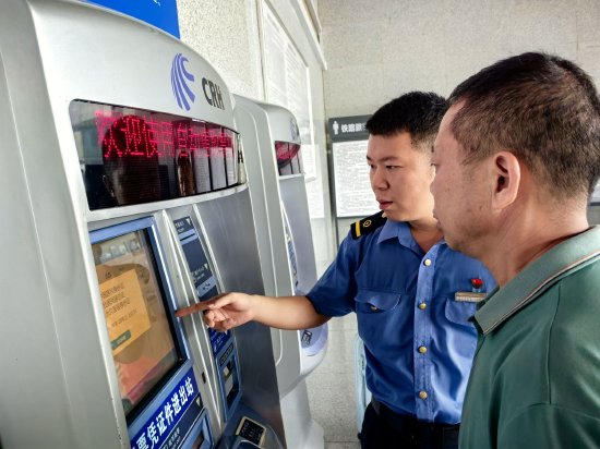 6.客运值班员游周存在售票厅内教旅客使用自助售票机办理购票。王玉 摄