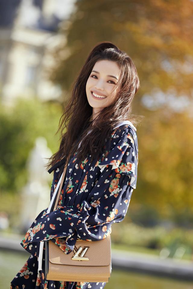 巴黎公园身穿碎花上衣搭配紧身长裤,飘逸的长发甜美的气质太好看了