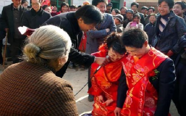 村里结婚新郎新娘身披缎面给长辈挨个敬酒近亲长辈要给新人红包