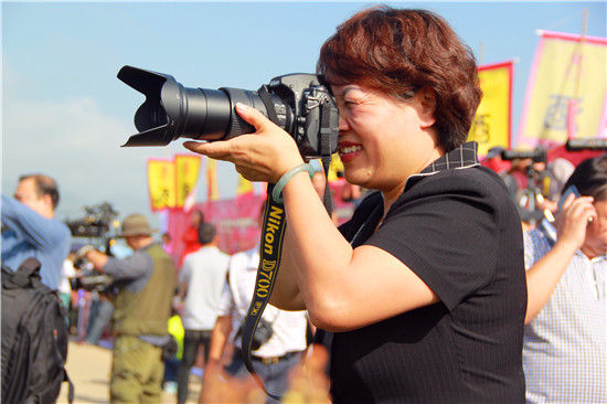 云南省罗平县委副书记、县长吕品红与摄影家一道拍摄宣传滇王老窖洞藏珍品名酒