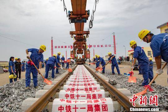 图为，9月21日，建设者在湖北省潜江市境内江汉铁路潜江北站进行最后一排钢轨铺设作业。徐云华 摄