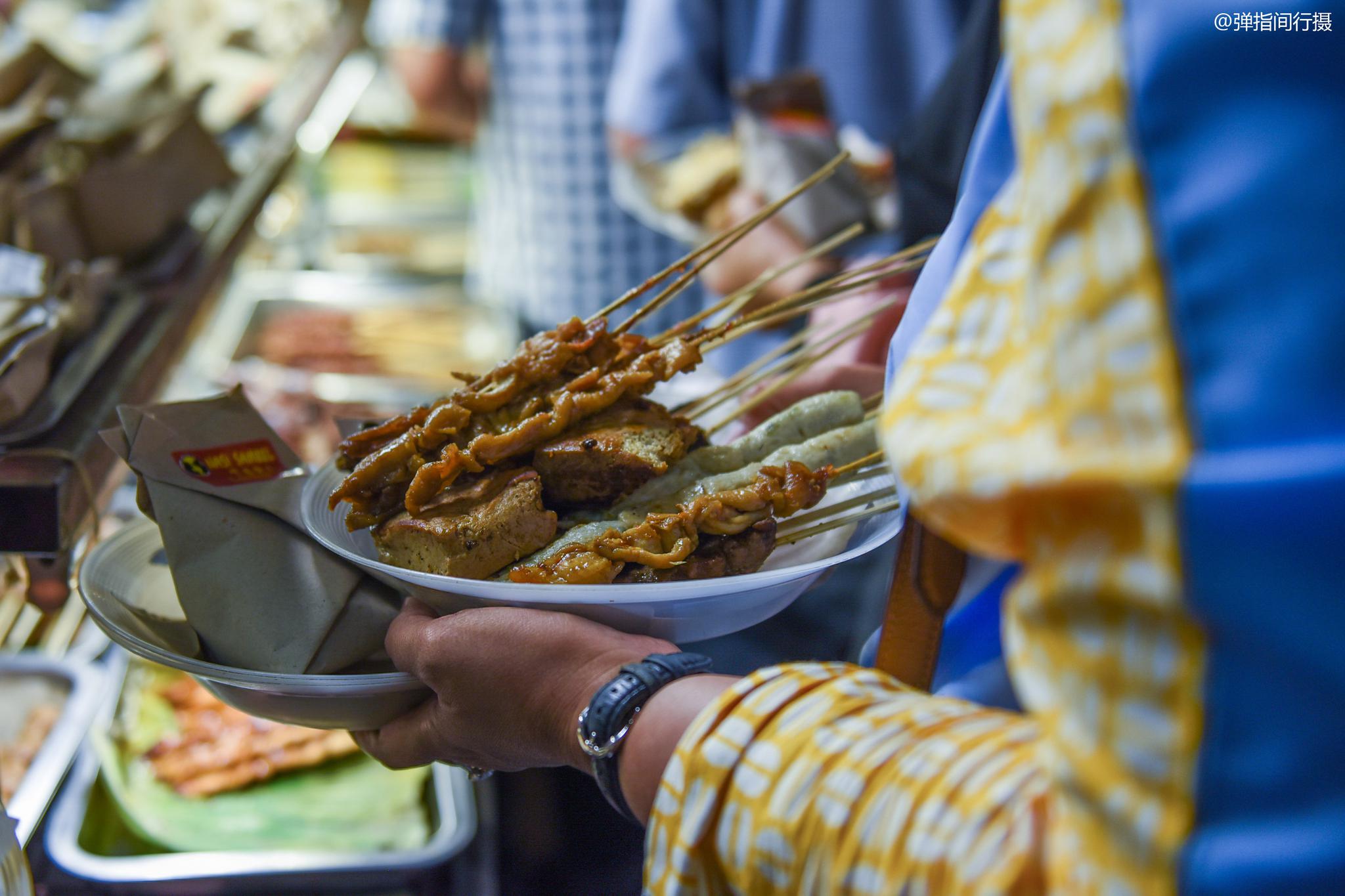 印尼夫妻档经营的路边摊,食客席地而吃,每天收入1000多万