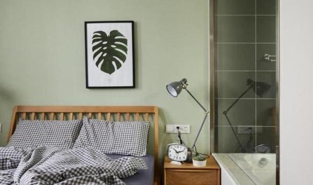 卧室的墙面采用了豆绿色乳胶漆进行涂刷,搭配素色格子纹路的窗帘以及