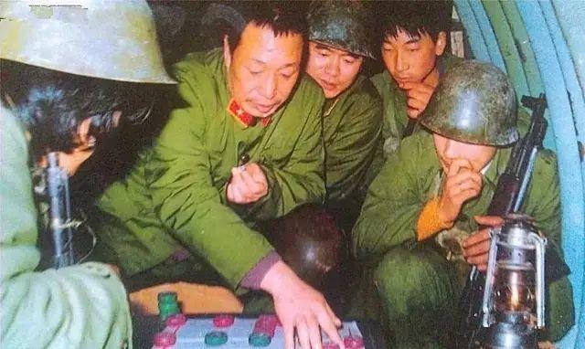 郑广臣师长在猫耳洞与战士下棋