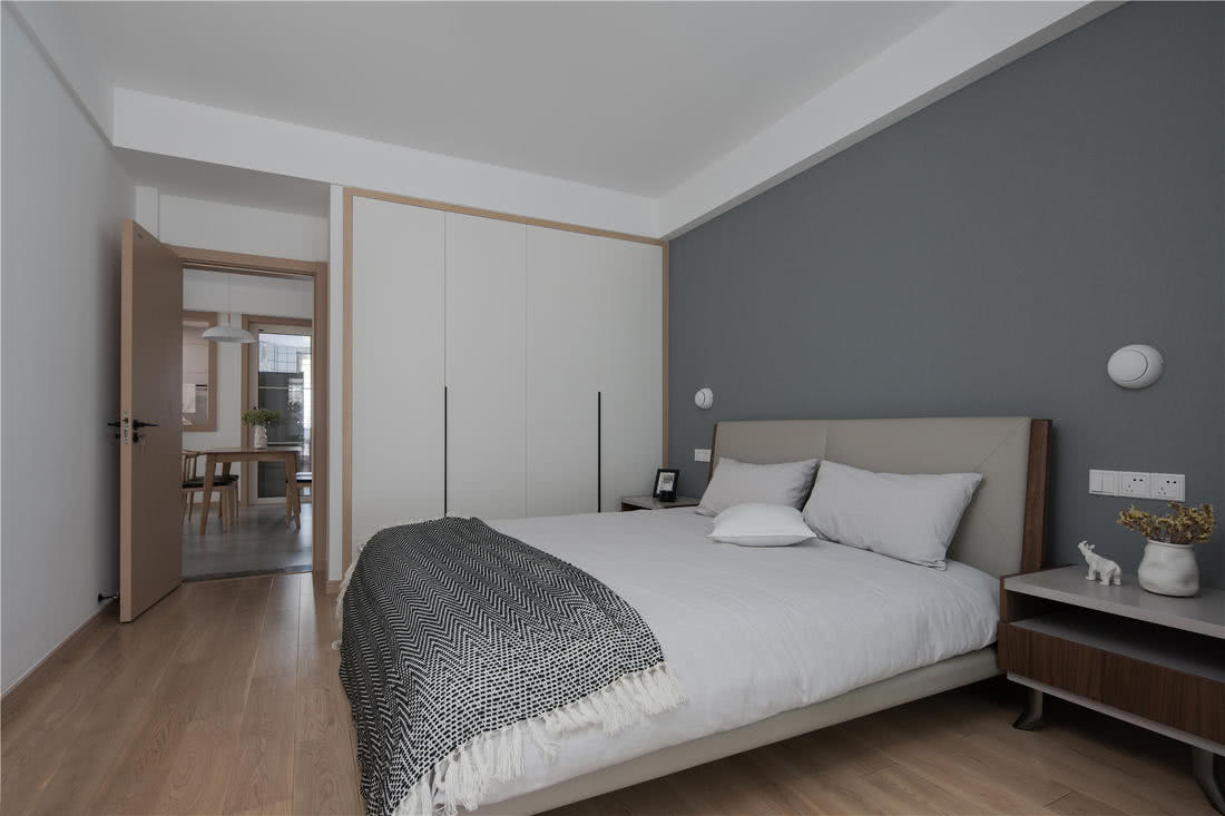 卧室同样是从简约出发,白色的衣柜与吊顶提亮空间,中性色硬包大床与