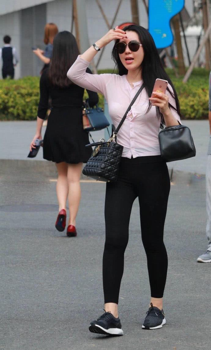 街拍:小姐姐紧身黑裤搭配白色t恤,肉肉的看着也是蛮好看的