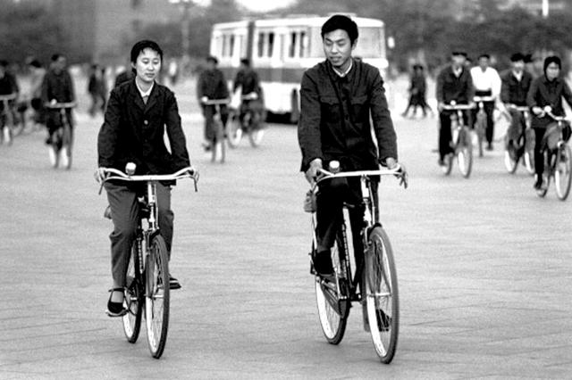上世纪80年代,南京路上市民或推或骑着老式"二八"自行车.
