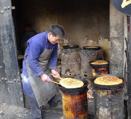 大叔路边卖大饼,一个五六个人都吃不完,切开之后感到货真价实
