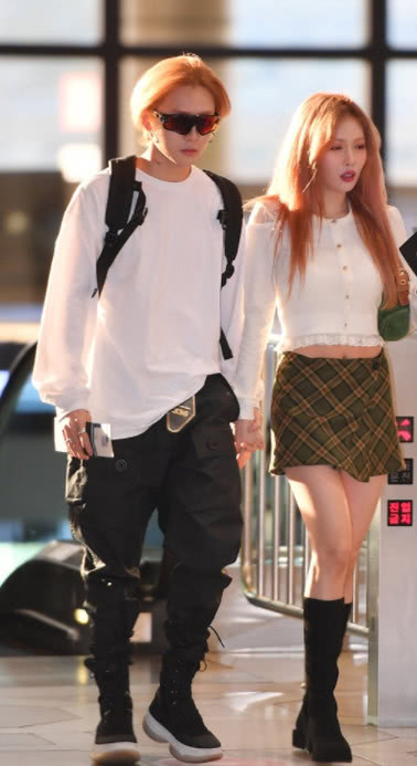 金泫雅身穿白色针织衫搭配格纹短裙和金晓钟手牵手现身非常甜腻