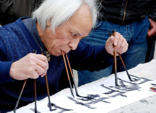 七旬老人街头展绝技用8支毛笔同时写书法高手在民间啊