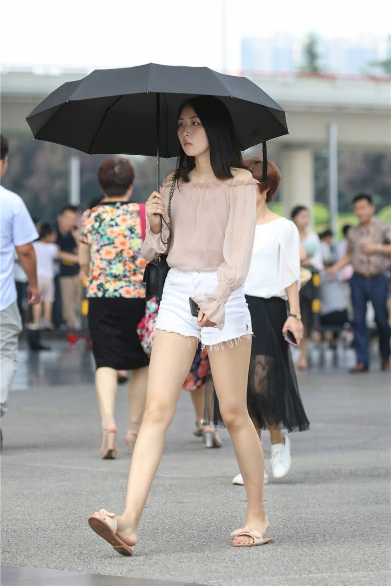 街拍美女阳光下撑伞的热裤大长腿女孩笑一笑会更美