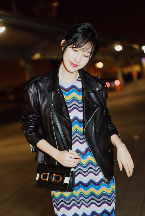迪丽热巴酷感十足的黑色皮衣搭配字母笑脸印花t恤以及精致黑白格子的