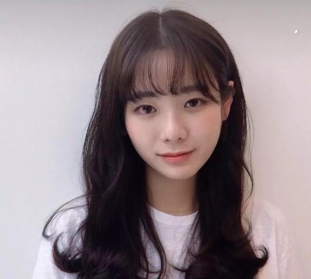 如果担心卷发不够减龄或者脸大的女生,可以留一个空气刘海.