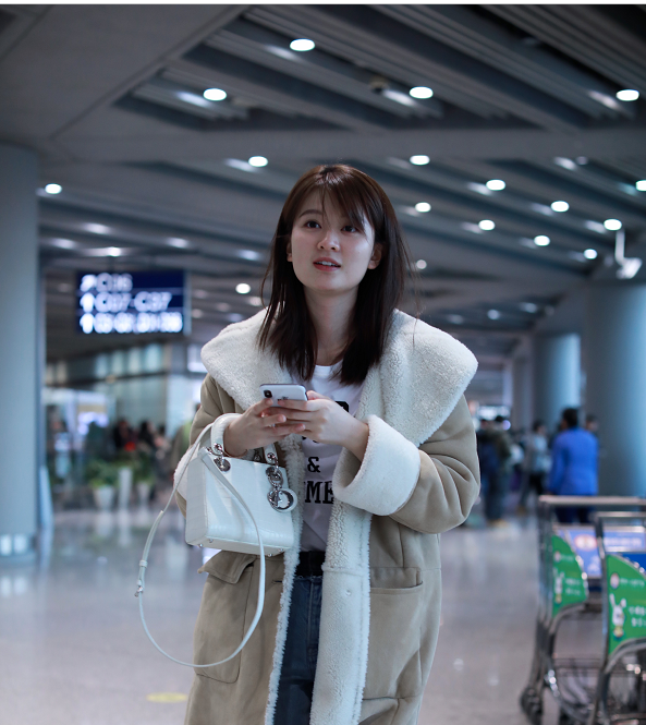 乔欣身穿米色翻领羊羔毛大衣内搭白现身机场 素颜亮相气质清新