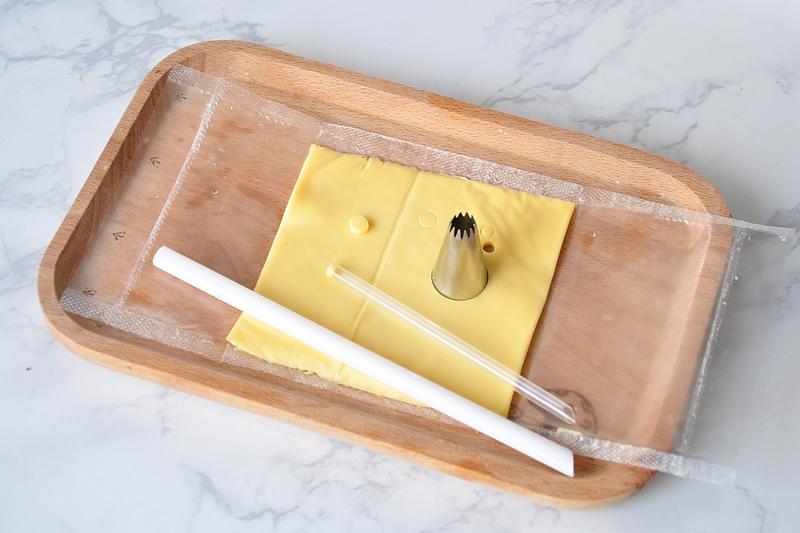 4用吸管和裱花嘴在芝士上压出小猪的鼻子,眼睛.