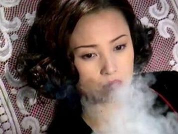 蒋勤勤的抽烟姿势是非常的娴熟,淡淡的妆容,浓浓的烟雾,让人感觉十分