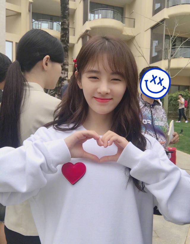 鞠婧祎用比心手势拍照,甜美的笑容尽显阳光自信的力量.