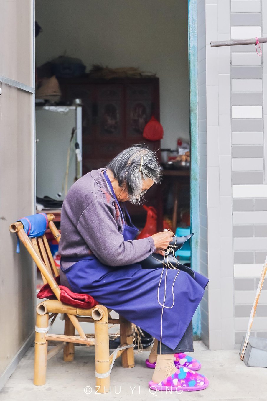 从栏杆外看到老奶奶正在缝制鞋子,画面美好,让我忍不住透过栏杆将这一